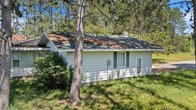 21837 Mishawaka Rd, Grand Rapids, MN 55744 - view of side of property with a chimney, roof with shingles, and a lawn