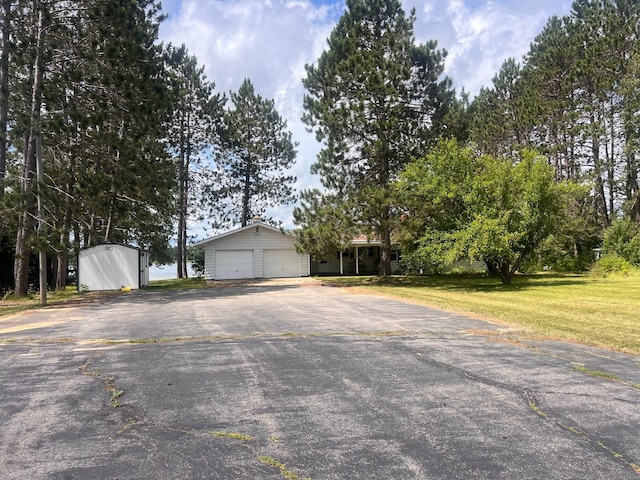 21837 Mishawaka Rd, Grand Rapids, MN 55744 - view of front facade featuring driveway, an attached garage, a front yard, and a shed