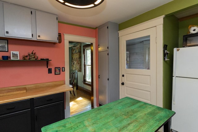 2912 15th Ave S, Minneapolis, MN 55407 - kitchen featuring freestanding refrigerator, light countertops, dark cabinetry, light wood finished floors, and open shelves