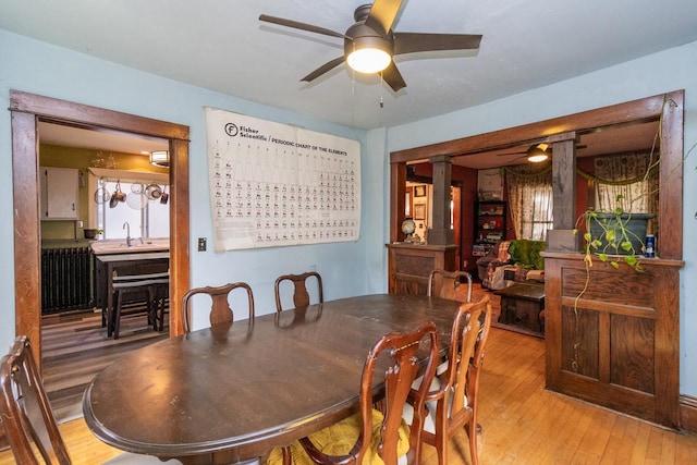 2912 15th Ave S, Minneapolis, MN 55407 - dining room featuring light wood-style floors, a ceiling fan, and ornate columns