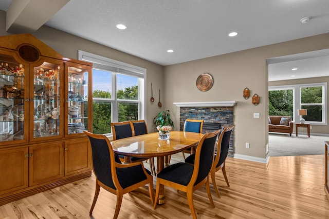 18837 Javelin Way, Lakeville, MN 55044 - dining area featuring light wood-style floors, recessed lighting, healthy amount of natural light, and a stone fireplace