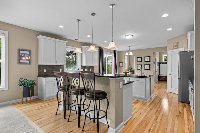 18837 Javelin Way, Lakeville, MN 55044 - kitchen featuring a kitchen island, light wood-style flooring, white cabinets, and recessed lighting