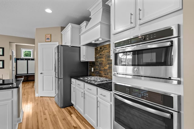 18837 Javelin Way, Lakeville, MN 55044 - kitchen featuring premium range hood, stainless steel appliances, dark countertops, white cabinetry, and decorative backsplash