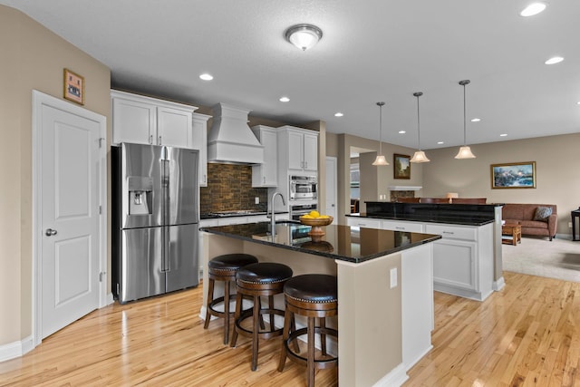 18837 Javelin Way, Lakeville, MN 55044 - kitchen featuring stainless steel refrigerator with ice dispenser, custom exhaust hood, open floor plan, a kitchen island with sink, and light wood-style floors