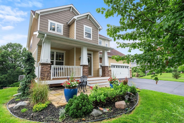 18837 Javelin Way, Lakeville, MN 55044 - craftsman-style house with covered porch, a front yard, asphalt driveway, stone siding, and an attached garage