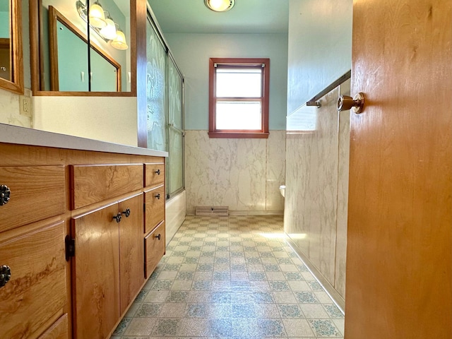 1224 Duba St, Worthington, MN 56187 - bathroom with enclosed tub / shower combo, vanity, tile patterned floors, and wainscoting