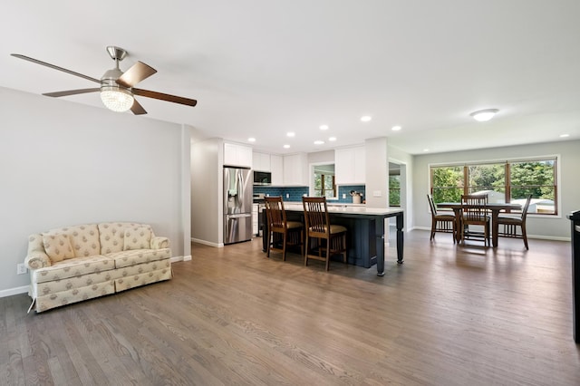 22470 Raven St NW, Oak Grove, MN 55011 - kitchen with appliances with stainless steel finishes, light countertops, a breakfast bar, wood finished floors, and white cabinetry