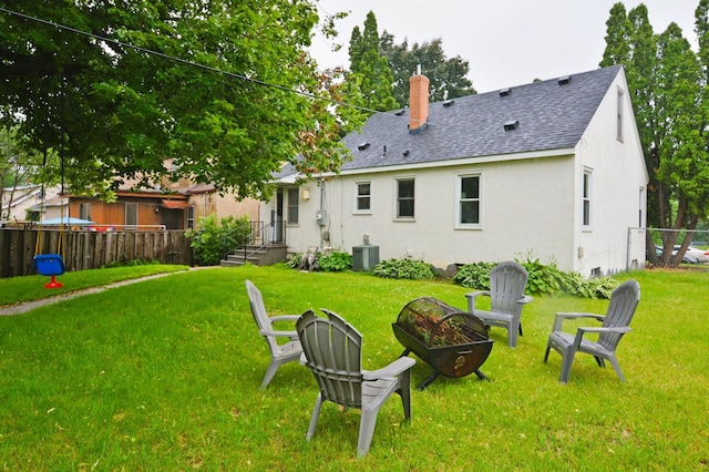 1631 Ross Ave, Saint Paul, MN 55106 - rear view of house featuring a shingled roof, an outdoor fire pit, a chimney, and stucco siding