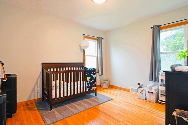 1631 Ross Ave, Saint Paul, MN 55106 - bedroom featuring wood finished floors and a nursery area