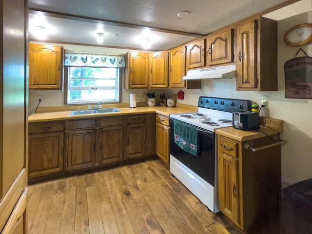 5566 Little Marais Rd, Crystal Bay Twp, MN 55603 - kitchen with white range with electric cooktop, under cabinet range hood, brown cabinetry, light countertops, and light wood finished floors
