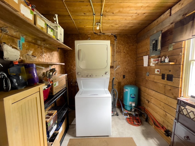 5566 Little Marais Rd, Crystal Bay Twp, MN 55603 - laundry area featuring stacked washer and clothes dryer, electric panel, wooden ceiling, and wooden walls