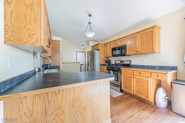 3730 Taylor St S, Fargo, ND 58104 - kitchen featuring appliances with stainless steel finishes, light wood finished floors, dark countertops, vaulted ceiling, and hanging light fixtures