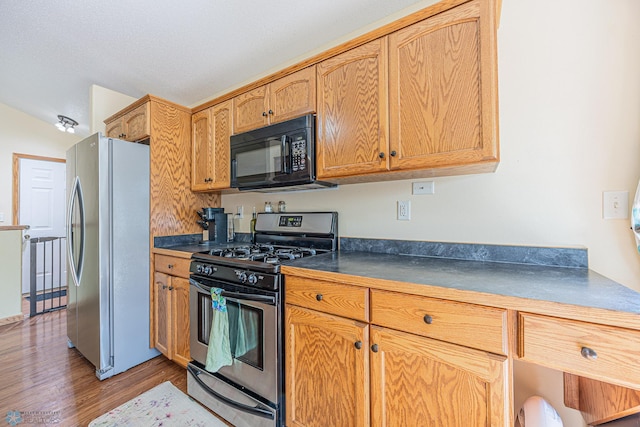 3730 Taylor St S, Fargo, ND 58104 - kitchen with stainless steel appliances, dark countertops, and light wood-type flooring