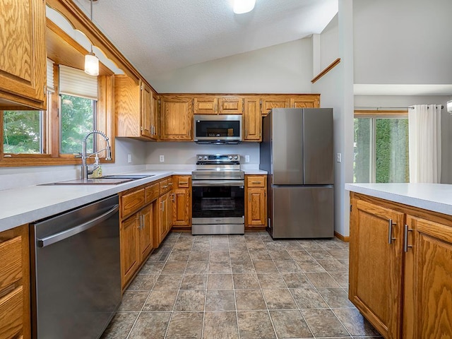 133 Summerfield Ct, Waverly, MN 55390 - kitchen with stainless steel appliances, vaulted ceiling, brown cabinets, light countertops, and healthy amount of natural light