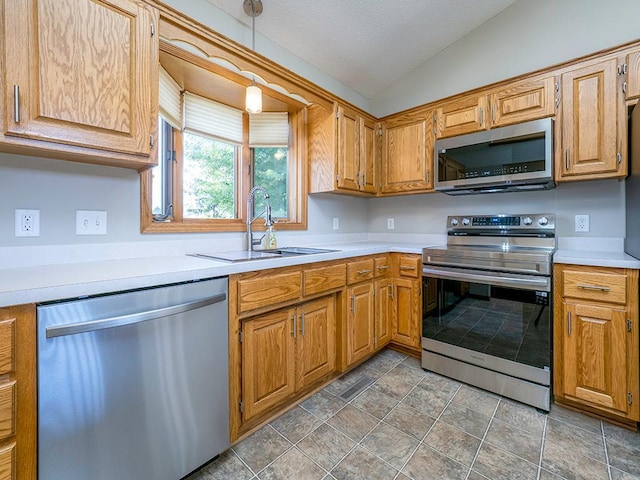 133 Summerfield Ct, Waverly, MN 55390 - kitchen with appliances with stainless steel finishes, light countertops, lofted ceiling, hanging light fixtures, and brown cabinets