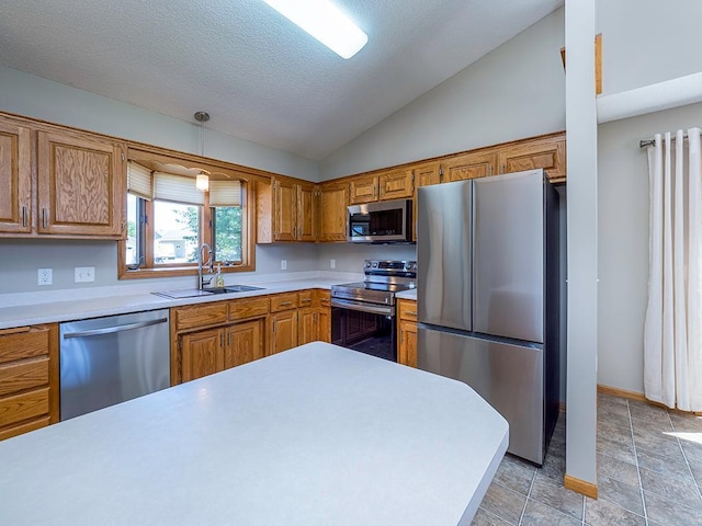 133 Summerfield Ct, Waverly, MN 55390 - kitchen featuring appliances with stainless steel finishes, vaulted ceiling, light countertops, brown cabinetry, and a textured ceiling