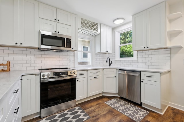 2440 37th Ave S, Minneapolis, MN 55406 - kitchen featuring appliances with stainless steel finishes, open shelves, white cabinets, dark wood-style floors, and decorative backsplash