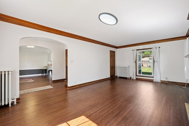 2440 37th Ave S, Minneapolis, MN 55406 - unfurnished living room with radiator heating unit, dark wood finished floors, crown molding, and arched walkways