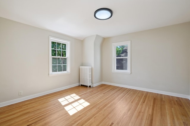 2440 37th Ave S, Minneapolis, MN 55406 - unfurnished room with radiator heating unit, light wood-style floors, and plenty of natural light