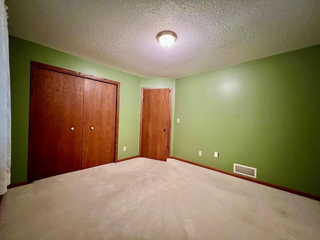 1002 6th Ave N, Wheaton, MN 56296 - unfurnished bedroom featuring carpet flooring, a closet, and a textured ceiling