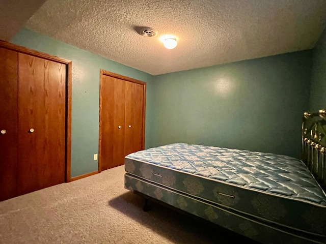 1002 6th Ave N, Wheaton, MN 56296 - carpeted bedroom featuring two closets and a textured ceiling