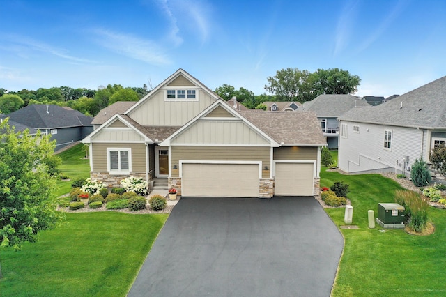4364 Ginger Dr, Minnetrista, MN 55331 - craftsman house featuring board and batten siding, a garage, a front lawn, asphalt driveway, and stone siding