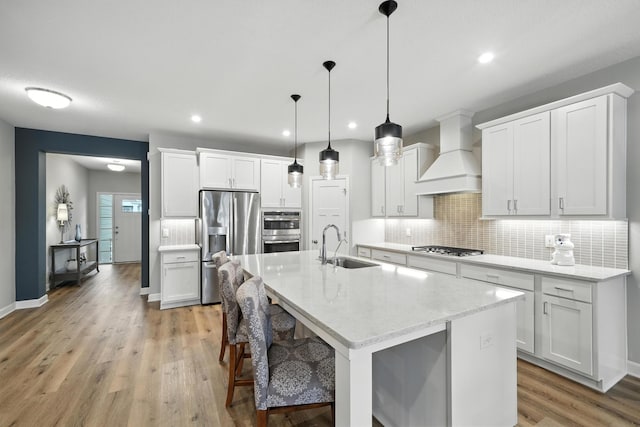 4364 Ginger Dr, Minnetrista, MN 55331 - kitchen featuring appliances with stainless steel finishes, custom exhaust hood, backsplash, light wood-style floors, and white cabinetry