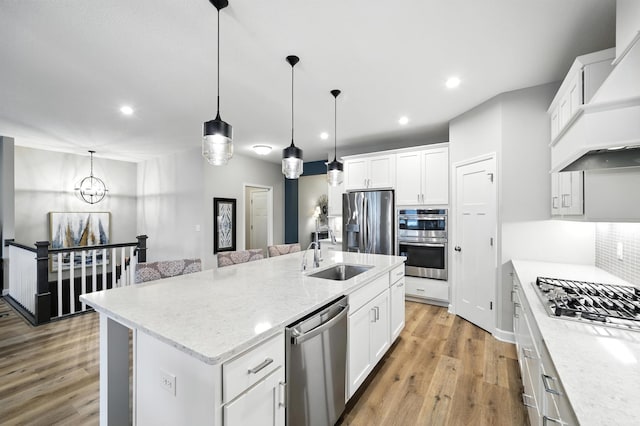 4364 Ginger Dr, Minnetrista, MN 55331 - kitchen featuring appliances with stainless steel finishes, premium range hood, a kitchen island with sink, light wood-style floors, and recessed lighting