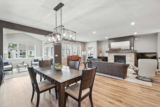 4364 Ginger Dr, Minnetrista, MN 55331 - dining space featuring light wood-style flooring, a stone fireplace, plenty of natural light, recessed lighting, and a chandelier