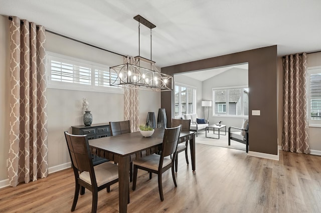 4364 Ginger Dr, Minnetrista, MN 55331 - dining room with a chandelier, wood finished floors, and vaulted ceiling