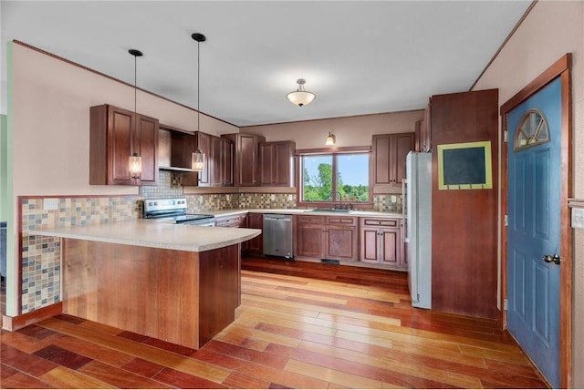 2832 130th Ave, Glenwood City, WI 54013 - kitchen with appliances with stainless steel finishes, a peninsula, light wood finished floors, light countertops, and decorative backsplash