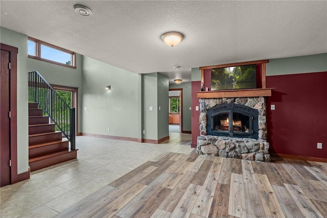 2832 130th Ave, Glenwood City, WI 54013 - unfurnished living room with stairs, a textured ceiling, wood finished floors, and a fireplace