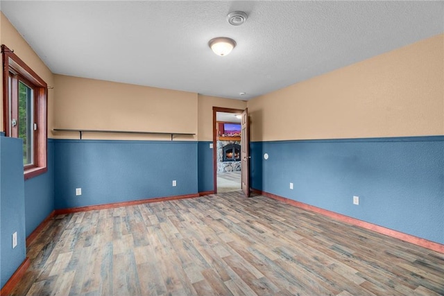 2832 130th Ave, Glenwood City, WI 54013 - unfurnished room with wood finished floors, a smoke detector, and a textured ceiling