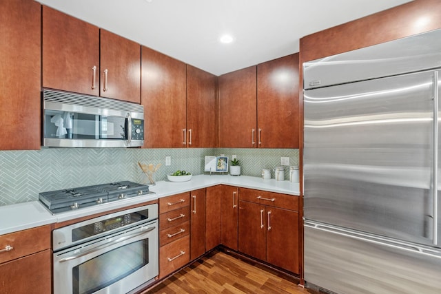 100 3rd Ave S Unit 805, Minneapolis, MN 55401 - kitchen featuring stainless steel appliances, wood finished floors, light countertops, decorative backsplash, and recessed lighting