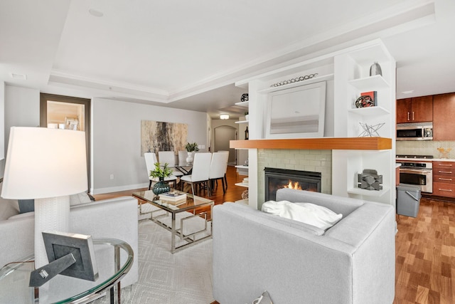 100 3rd Ave S Unit 805, Minneapolis, MN 55401 - living room featuring light wood-style flooring, a raised ceiling, and a brick fireplace