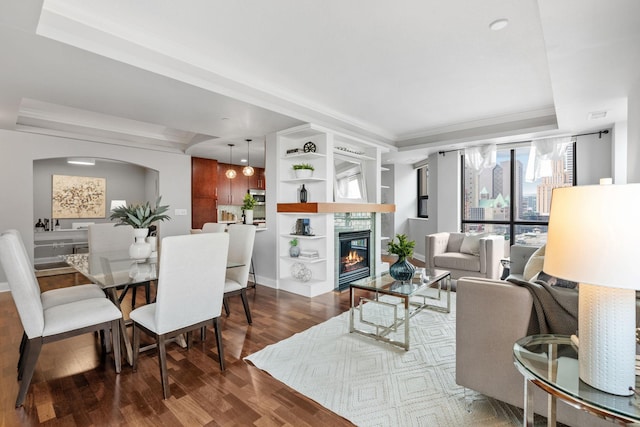 100 3rd Ave S Unit 805, Minneapolis, MN 55401 - living room with wood finished floors, a tray ceiling, built in features, a glass covered fireplace, and arched walkways