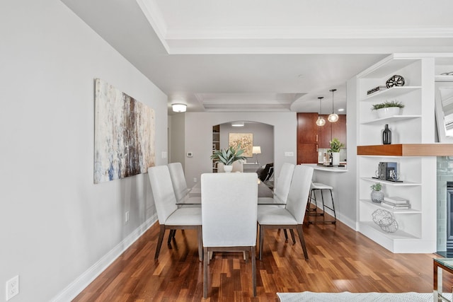 100 3rd Ave S Unit 805, Minneapolis, MN 55401 - dining space featuring arched walkways, a tray ceiling, wood finished floors, built in shelves, and crown molding