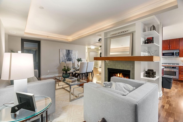 100 3rd Ave S Unit 805, Minneapolis, MN 55401 - living room with light wood-style floors, a tray ceiling, crown molding, and a fireplace