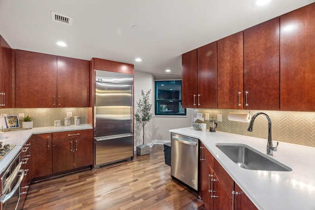 100 3rd Ave S Unit 805, Minneapolis, MN 55401 - kitchen with appliances with stainless steel finishes, wood finished floors, tasteful backsplash, light countertops, and recessed lighting