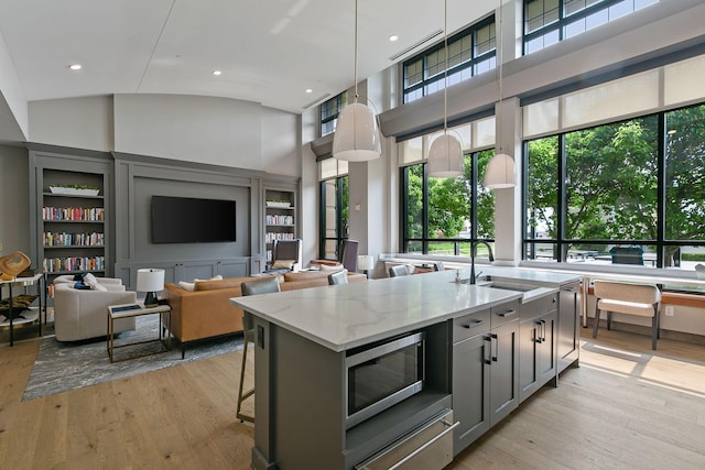 100 3rd Ave S Unit 805, Minneapolis, MN 55401 - kitchen featuring stainless steel microwave, built in features, a warming drawer, gray cabinetry, and a center island with sink