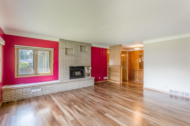 2808 34th Ave NE, Saint Anthony, MN 55418 - unfurnished living room with wood finished floors and a brick fireplace