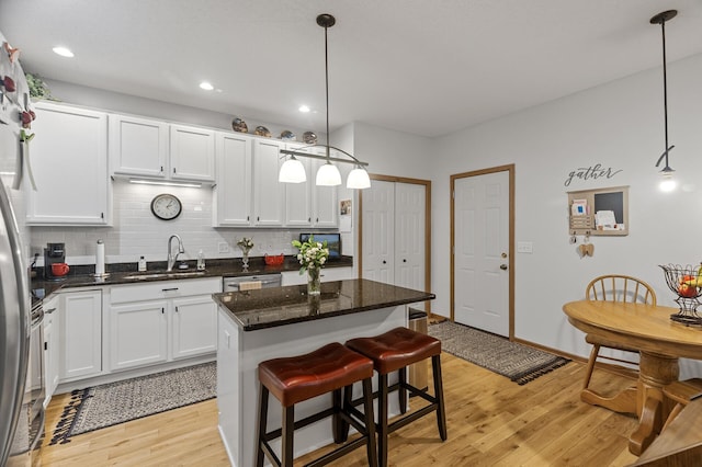 6511 98th Ln N, Brooklyn Park, MN 55445 - kitchen with backsplash, light wood-style flooring, a kitchen island, white cabinetry, and recessed lighting