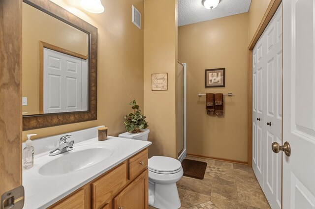 6511 98th Ln N, Brooklyn Park, MN 55445 - full bathroom featuring vanity, a shower stall, stone finish floors, and a textured ceiling