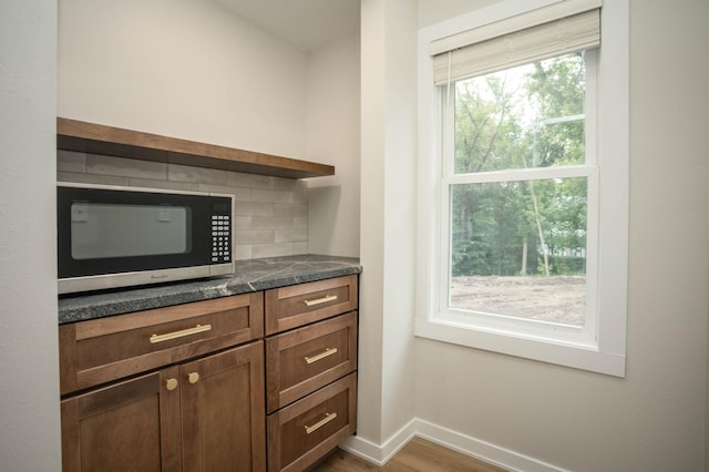 7591 Lake Ida Way NW, Alexandria, MN 56308 - kitchen featuring stainless steel microwave, dark countertops, wood finished floors, open shelves, and backsplash