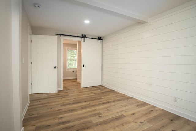 7591 Lake Ida Way NW, Alexandria, MN 56308 - unfurnished room featuring a smoke detector, wood finished floors, a barn door, beamed ceiling, and recessed lighting