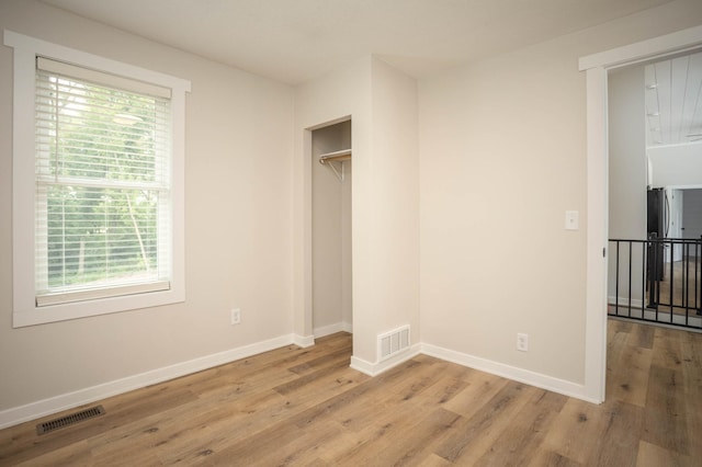 7591 Lake Ida Way NW, Alexandria, MN 56308 - unfurnished bedroom featuring multiple windows and wood finished floors