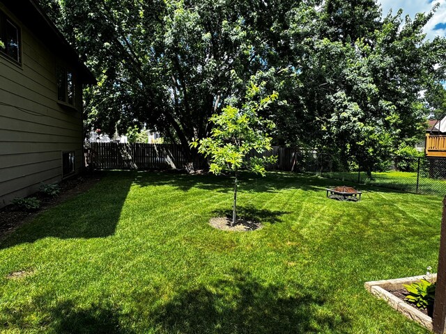 6314 112th Pl N, Champlin, MN 55316 - fenced backyard featuring an outdoor fire pit