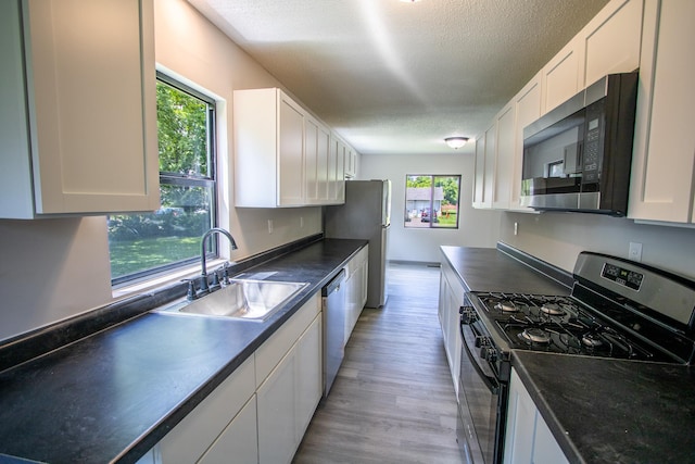 422 Park Ave, Sandstone, MN 55072 - kitchen with appliances with stainless steel finishes, dark countertops, white cabinets, and a textured ceiling