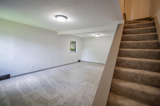 422 Park Ave, Sandstone, MN 55072 - basement featuring stairway, carpet, and a textured ceiling