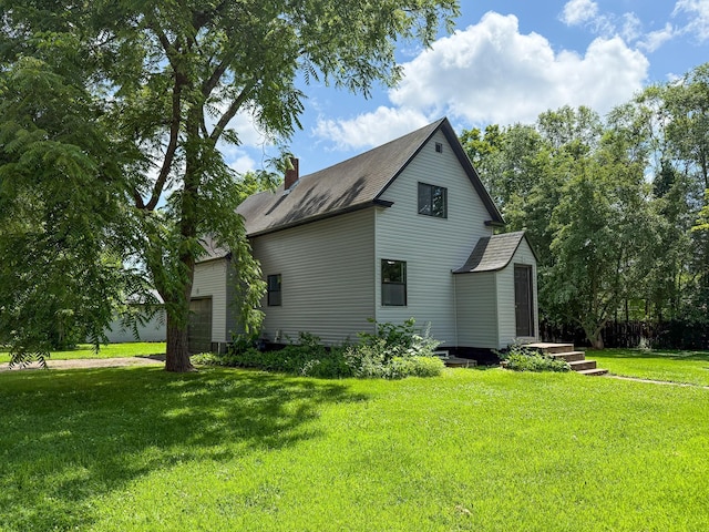 422 Park Ave, Sandstone, MN 55072 - view of side of home featuring a lawn, a chimney, and an attached garage